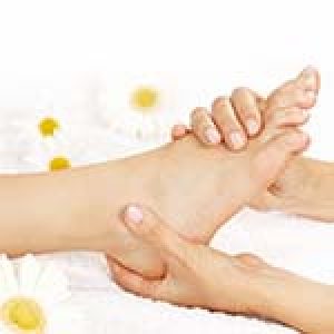 Female hands giving massage to soft bare foot